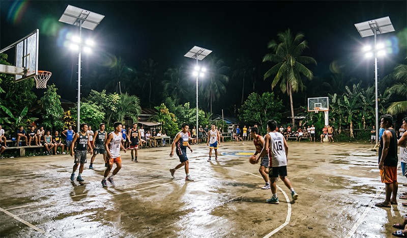 Philippine community basketball court tournament at night illuminated by MCL Solar 200W solar floodlight systems