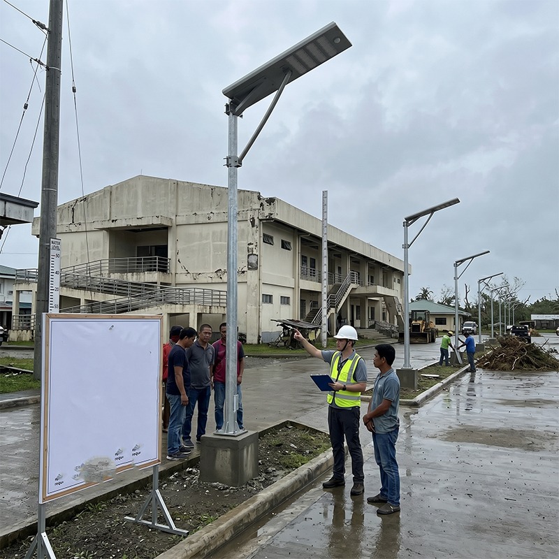Municipal engineers inspecting MCL Solar street light pole installation in rainy typhoon conditions in the Philippines